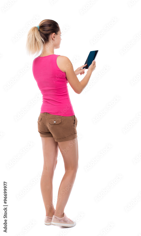 back view of standing young beautiful girl with tablet computer back view of standing young beautiful girl with tablet computer