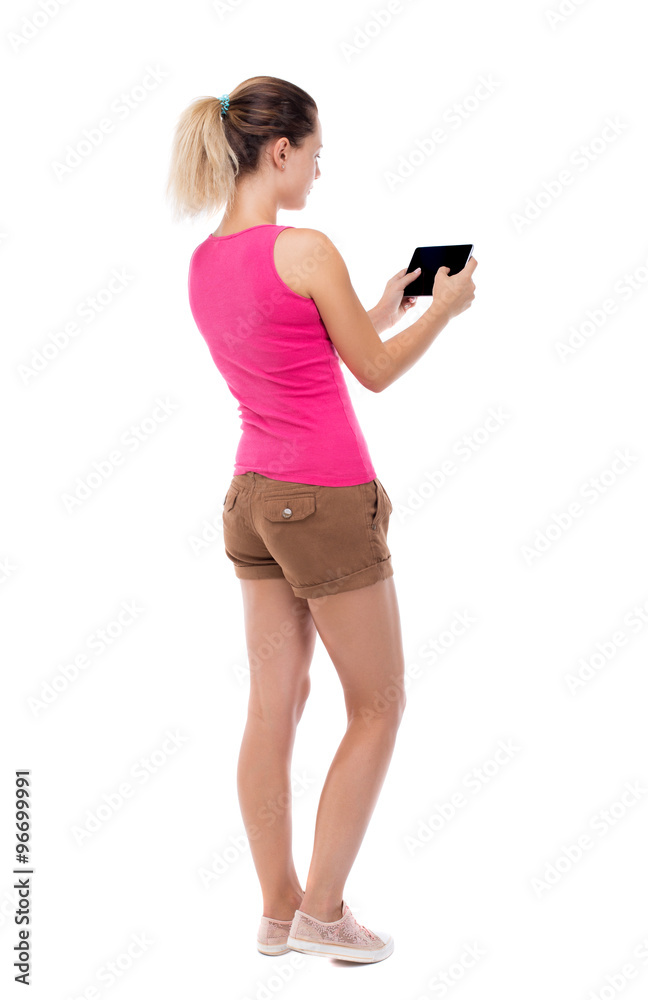 back view of standing young beautiful girl with tablet computer back view of standing young beautiful girl with tablet computer