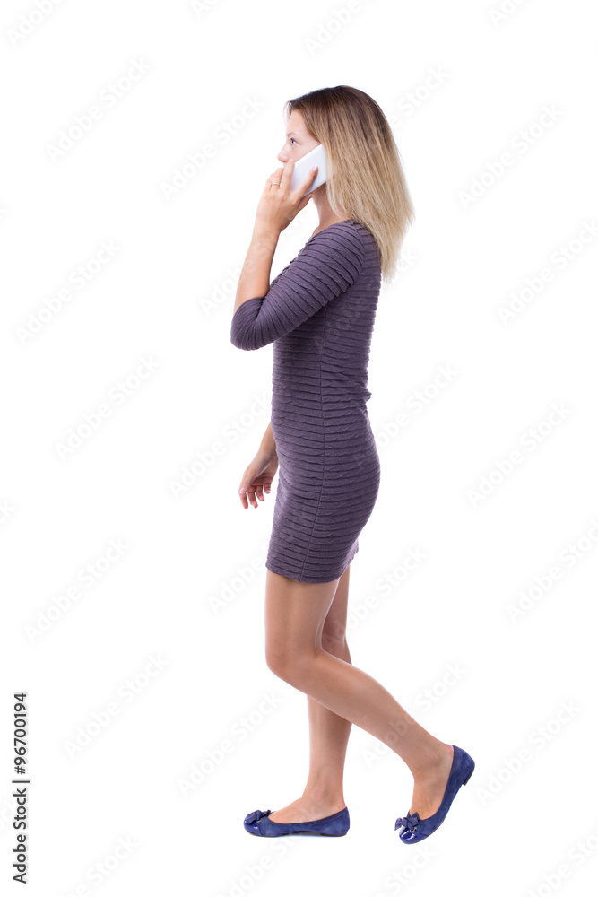 side view of a woman walking with a mobile phone. back view ofgi side view of a woman walking with a mobile phone. back view ofgi