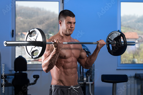 Young Man Lifting Weights With Barbell