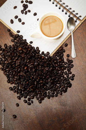 Coffee cup and beans on the book