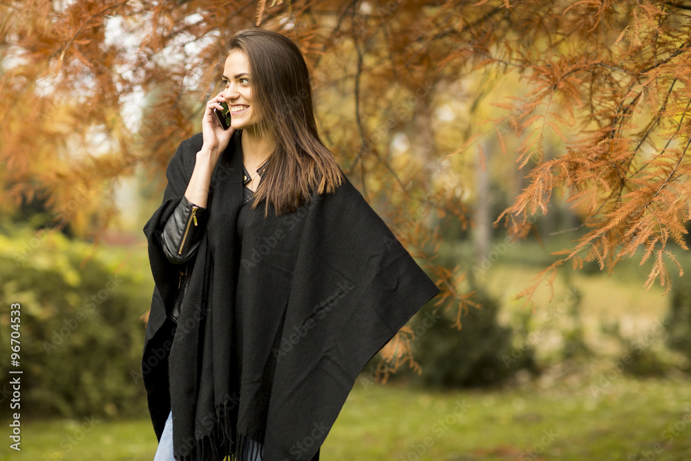 Woman with mobile phone in the autumn park Woman with mobile phone in the autumn park