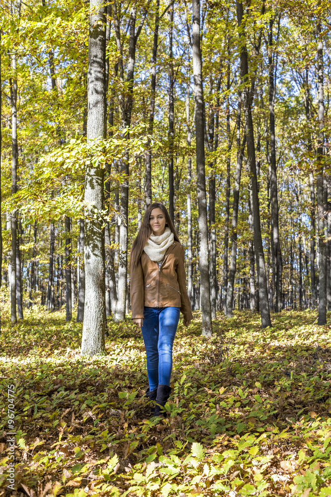 Pretty teenage girl walking in the forest.Autumn season