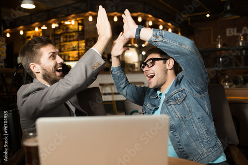 Happy lucky friends in a cafe sit at table photo