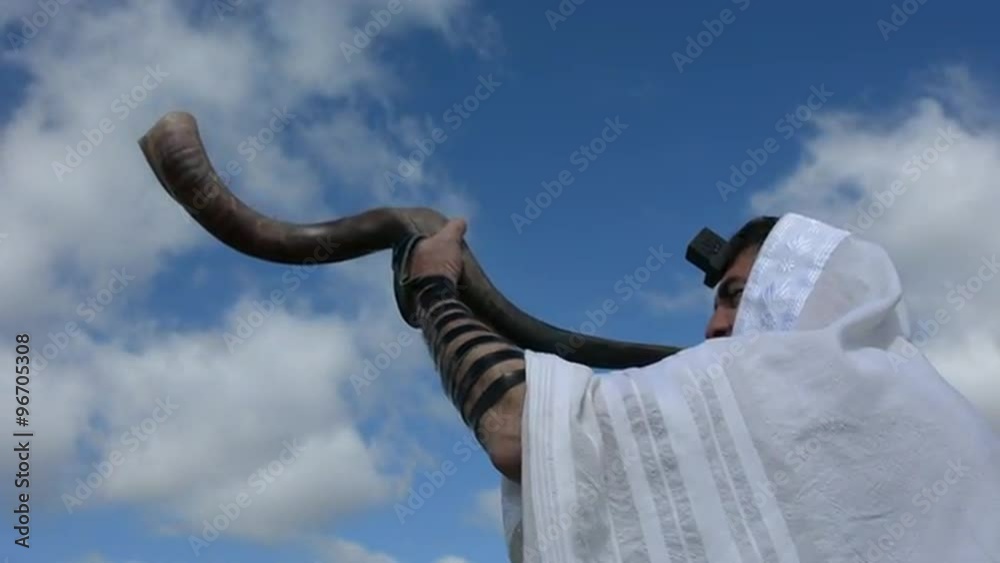 Jewish man blow Shofar (horn) outdoors under the sky, on the Jewish