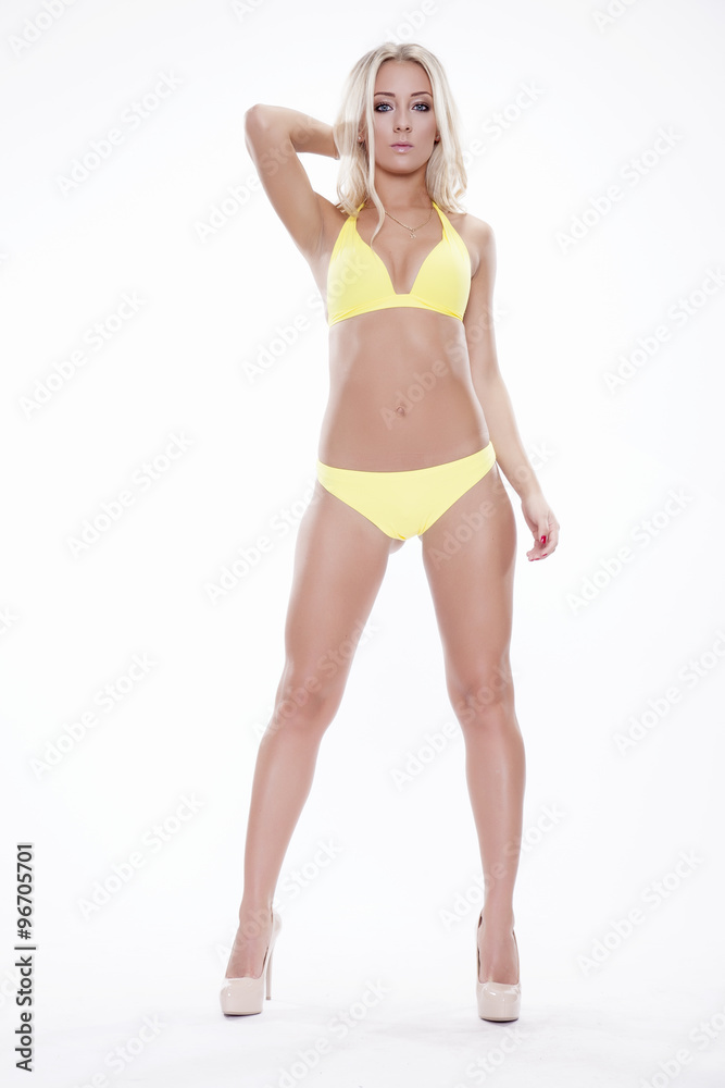 Sexy blonde woman wearing pink swimwear posing on white backgrou Sexy blonde woman wearing pink swimwear posing on white backgrou