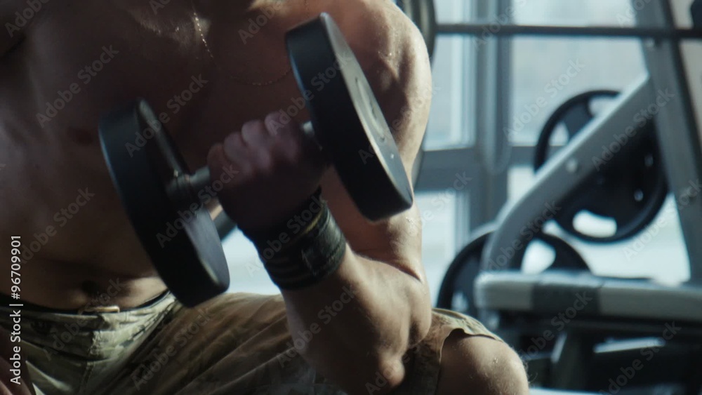 The bodybuilder does exercise with dumbbells The bodybuilder does exercise with dumbbells