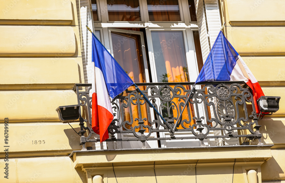 french flags in the window of a Parisian building