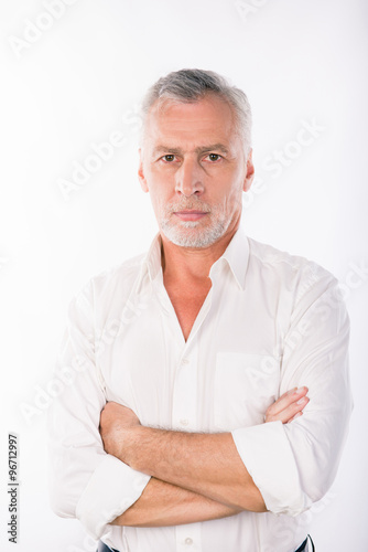 Handsome confident businessman with gray beard crossing hands