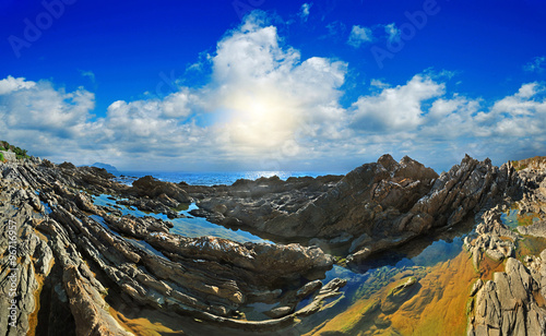 Stone rapids in the sea of blue sky with clouds