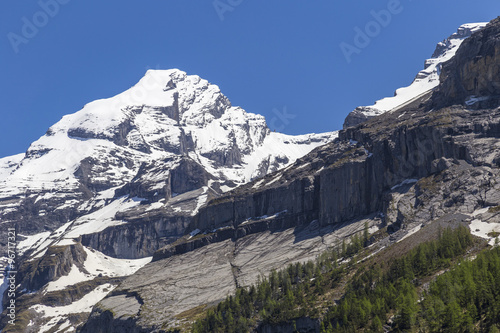 View of mountain rocks and ice-capped Swiss Alps near Oeschinensee in Bernese Oberland, Switzerland