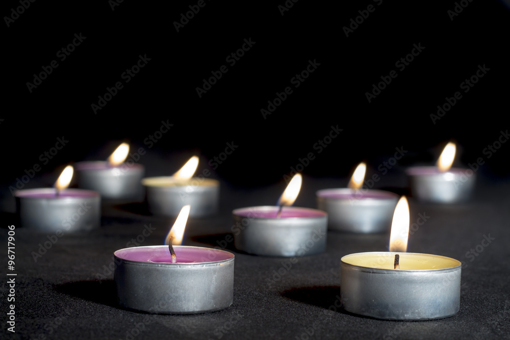 Scented candles of different fragrances, with metal base, on black background Scented candles of different fragrances, with metal base, on black background