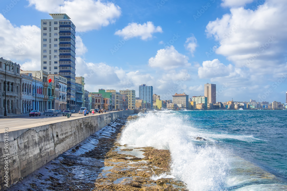 The skyline of Havana with waves crashing on the  seawall