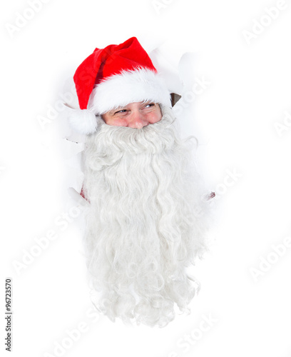 Santa Claus looking through hole in a white wall