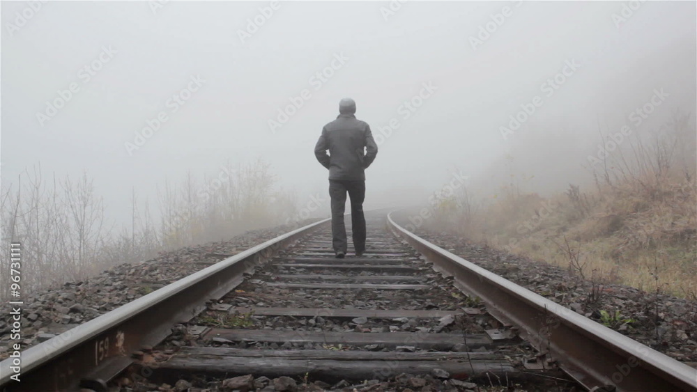 man goes in the fog/man goes walking in the fog on railway track