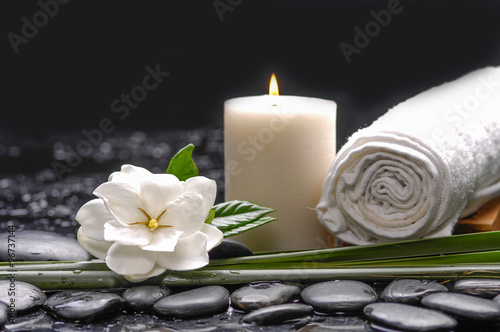 Still life with gardenia flowers with candle ,towel on therapy stones 