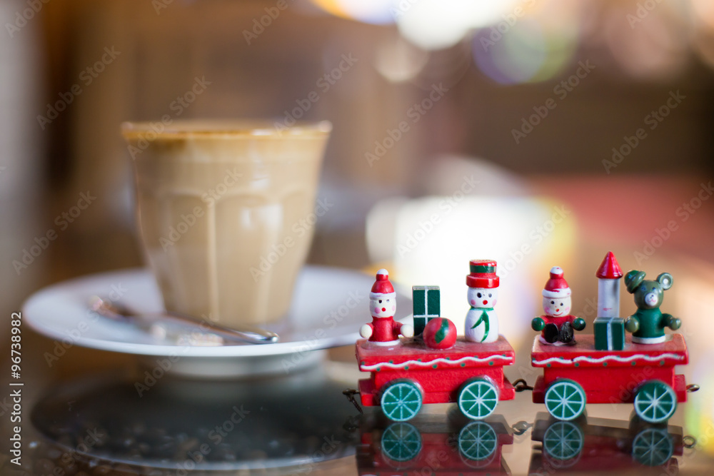 Hot art Latte Coffee in a cup and christmas toy on wooden table