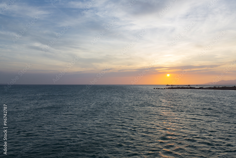 Naklejka premium Colorful ocean beach sunset with deep blue sky and sun rays on the harbor of Margarita, Venezuela.