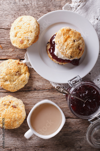 Delicious English scones with jam and tea closeup. vertical top view
