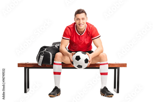 Young football player sitting on a bench