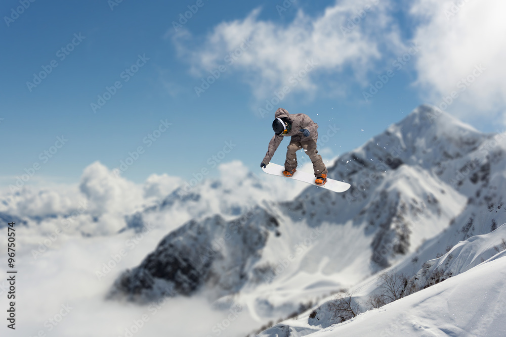 Flying snowboarder on mountains. Extreme sport.