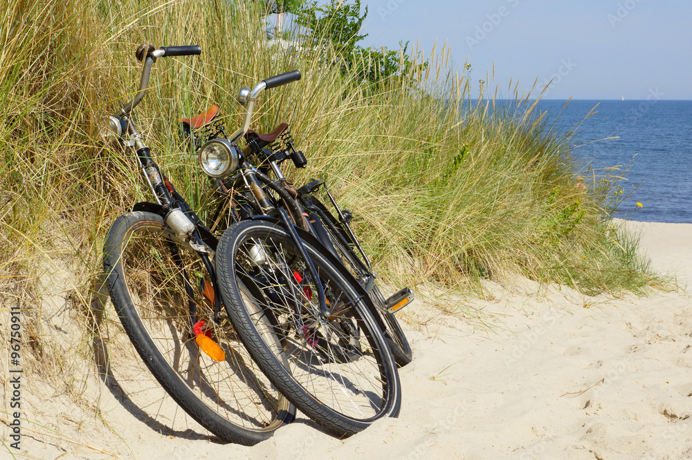 Fototapeta premium Two Bikes at the Summer Beach with Sea in the background