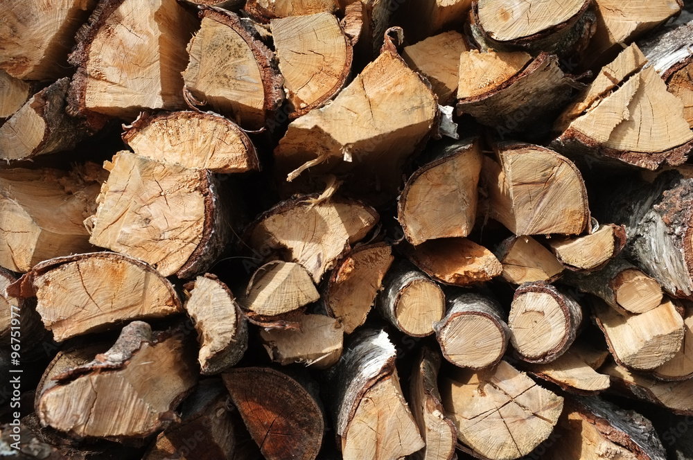 Background of dry chopped firewood logs stacked up in a pile Background of dry chopped firewood logs stacked up in a pile