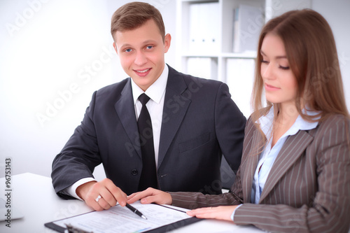 Image of businessman and business woman using clipboard at meeting