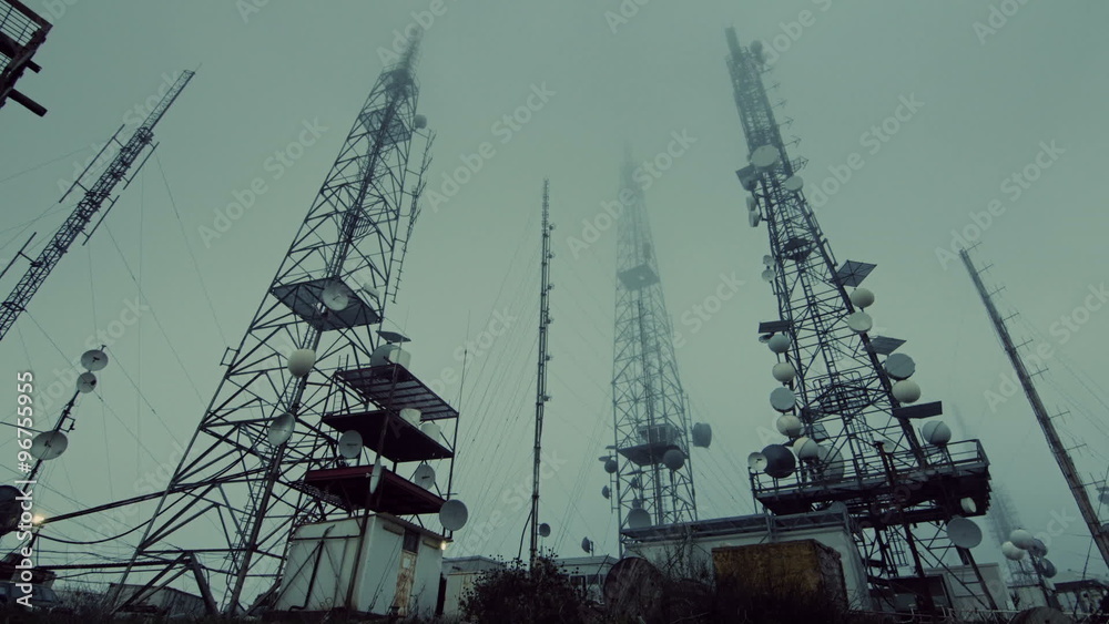 communication transmitters, antennas site, mountain mist and fog at dusk communication transmitters, antennas site, mountain mist and fog at dusk