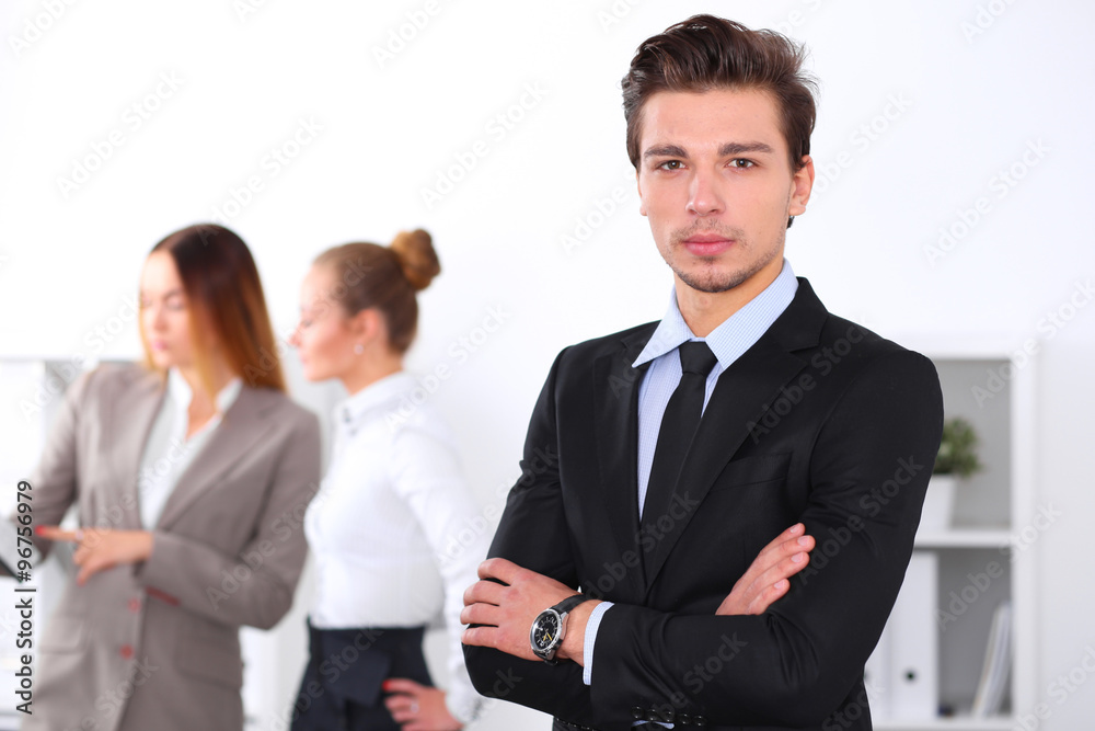 Cheerful business man in office with colleagues in the background, sturt up team Cheerful business man in office with colleagues in the background, sturt up team