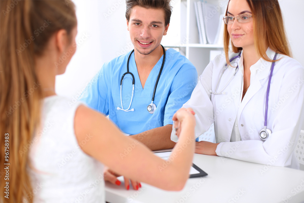Male doctor and female patient shaking hands. Partnership, trust and medical ethics concept Male doctor and female patient shaking hands. Partnership, trust and medical ethics concept