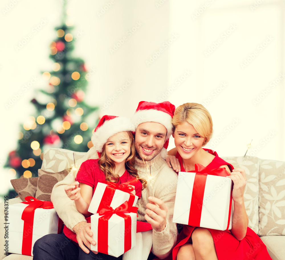 smiling family holding gift boxes and sparkles