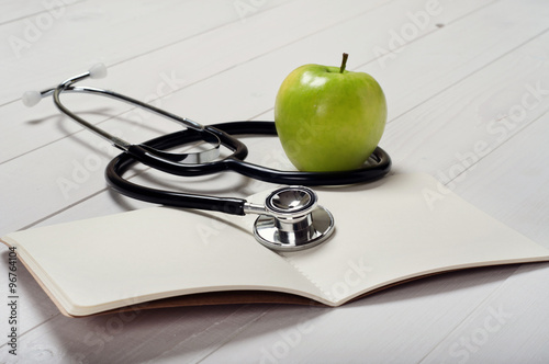 open notebook with blank pages with stethoscope and aplle photo