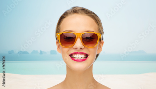 happy young woman in sunglasses with pink lipstick