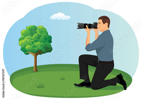Photographer is crouching in the countryside and taking a photo