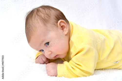 The baby lies on a stomach. A portrait on a light background