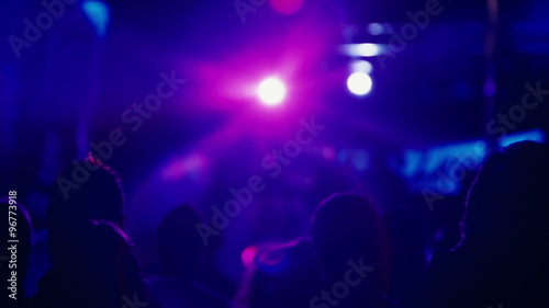 Dance club party people silhouetted backlit by colorful lights photo