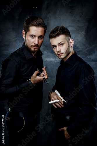 Elegant young handsome men.  Man with straight razor and man holding hairdressers scisors