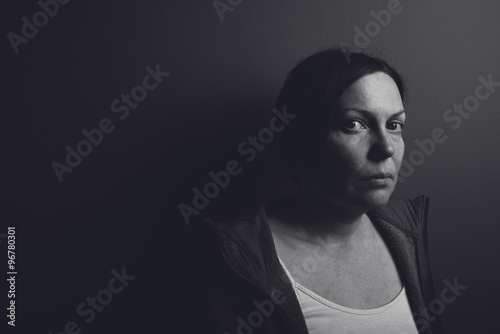 Intense low key portrait of pensive sad woman photo