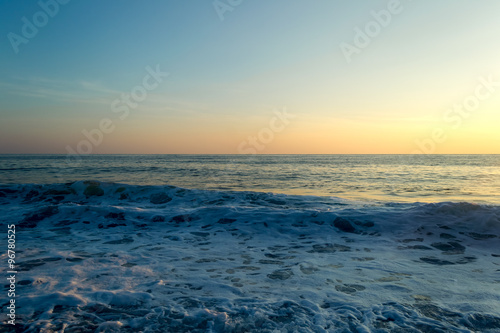 Waves breaking on a stony beach, forming sprays © binik