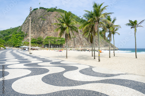 Scenic karst mountain landscape with iconic sidewalk tile pattern at the Leme end of Copacabana Beach in Rio de Janeiro, Brazil 