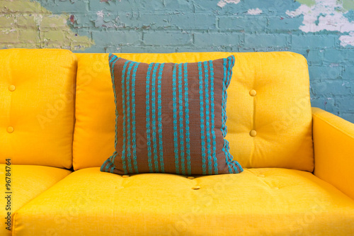 Close up of yellow fabric sofa and cushions