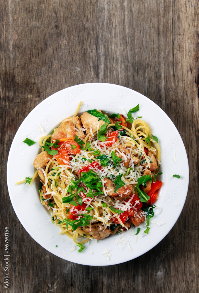 Italian Chicken Breast spaghetti with red pepper, Parmesan cheese and wild rocket lives. on old wooden table. Italian Chicken Breast spaghetti with red pepper, Parmesan cheese and wild rocket lives. on old wooden table.