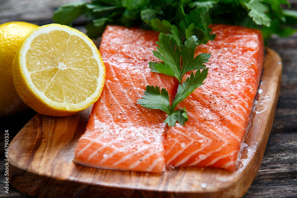 Raw Salmon fish fillet with fresh parsley on cutting board