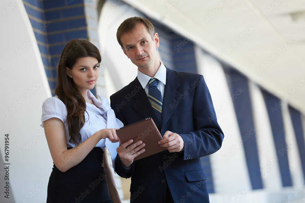 business woman and a businessman with a tablet
