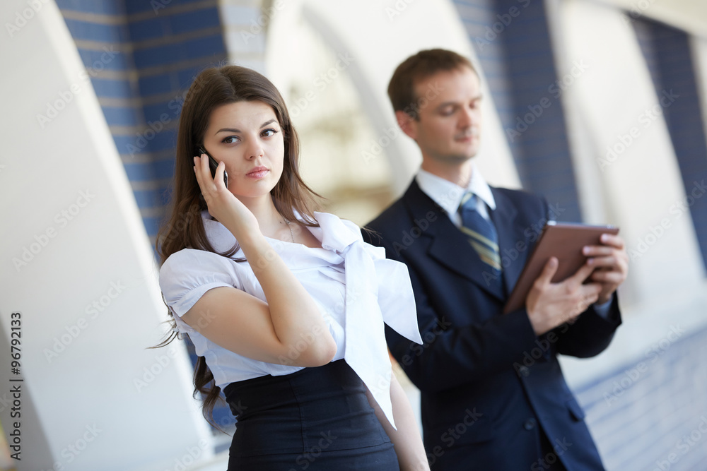 business woman with a telephone and a businessman with a tablet business woman with a telephone and a businessman with a tablet