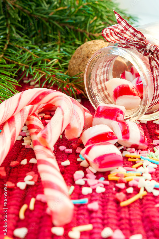 Sweet candies spilled/poured from glass jar on christmas backgro