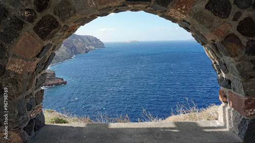 view through archway to aegean sea of santorini island photo