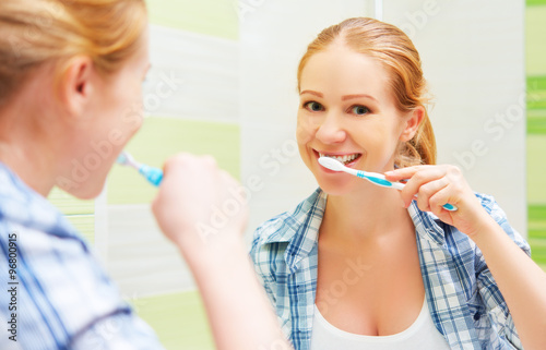 happy woman brushing her teeth with a toothbrush