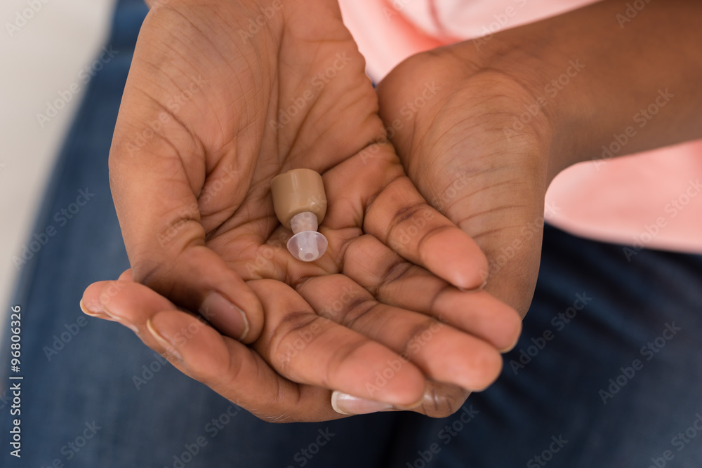 Person's Hand With Hearing Aid